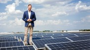 Georg Schmiedel standing between solar panels