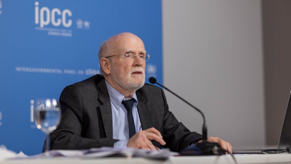 Mr Pörtner sitting at a table, speaking into a microphone