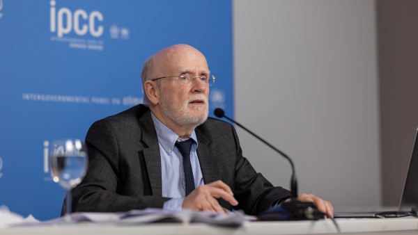 Mr Pörtner sitting at a table, speaking into a microphone