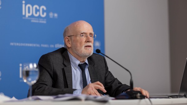 Mr Pörtner sitting at a table, speaking into a microphone