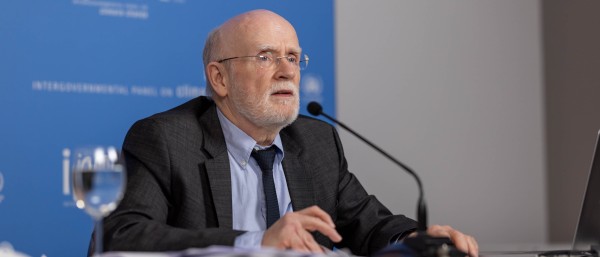 Mr Pörtner sitting at a table, speaking into a microphone