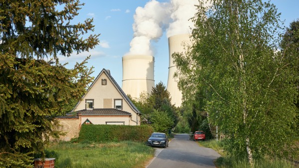 Einfamilienhaus mit zwei Kühltürmen im Hintergrund