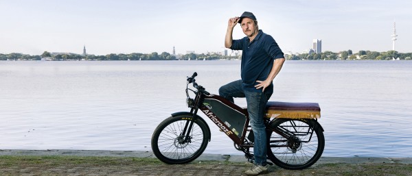 Schauspieler Bjarne Mädel auf dem African E-Bike an der Alster.