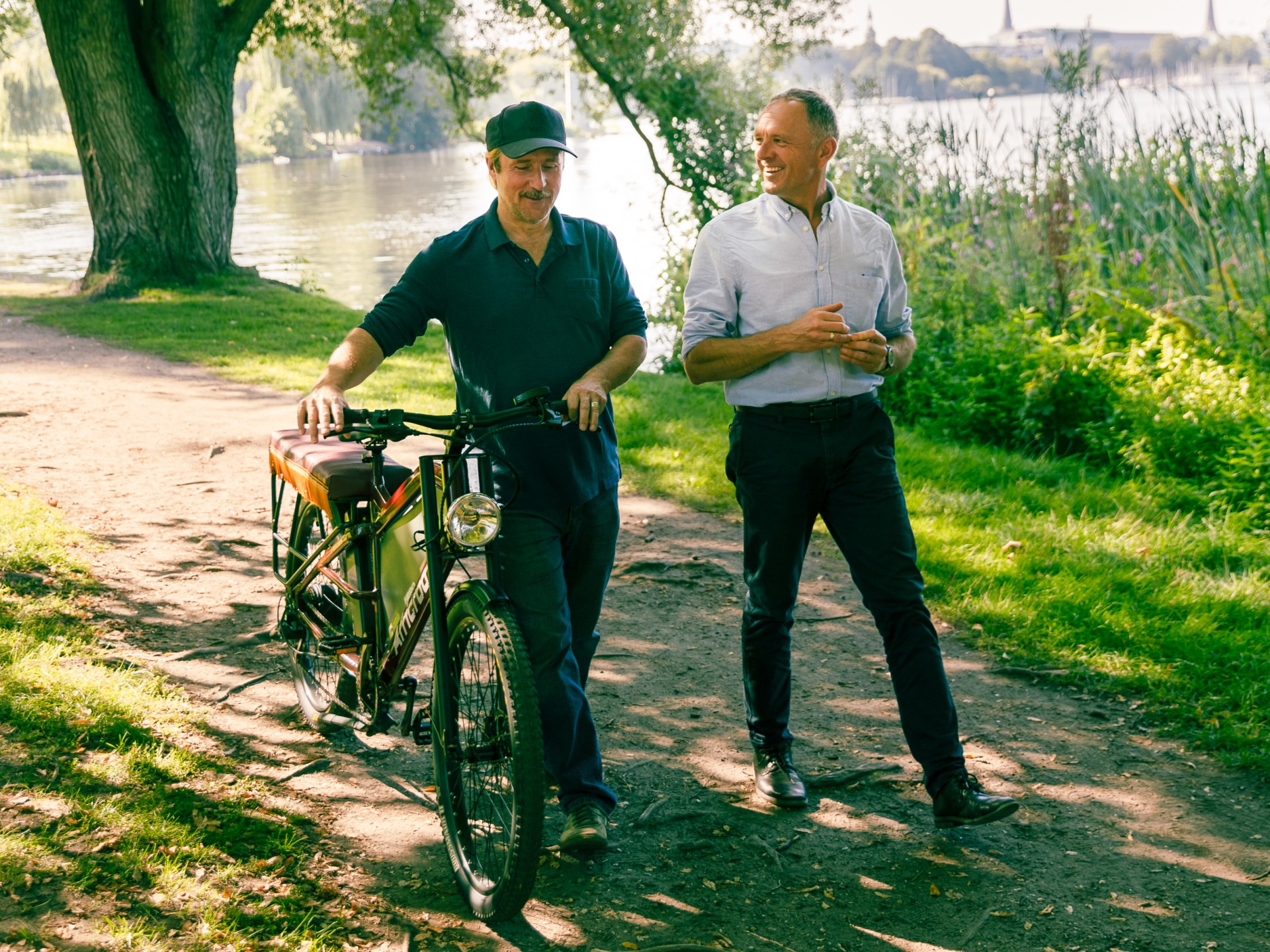 Bjarne Mädel schiebt das African E-Bike. Er und Jürgen Perschon unterhalten sich.