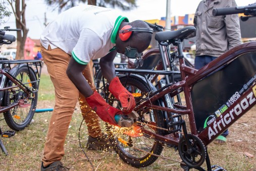 A man welding on the rear wheel of an e-bike.