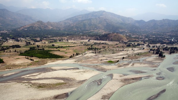 View over a valley with a winding river and mountains in the background