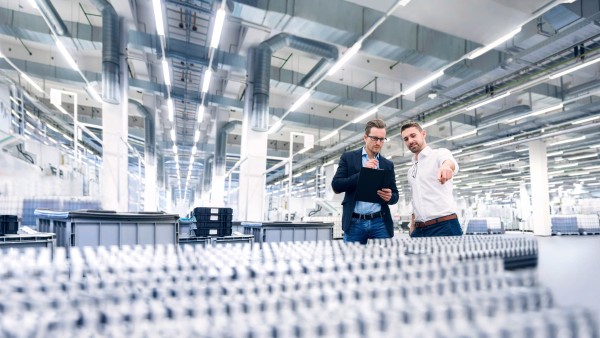 Two young men examine the products in a production hall