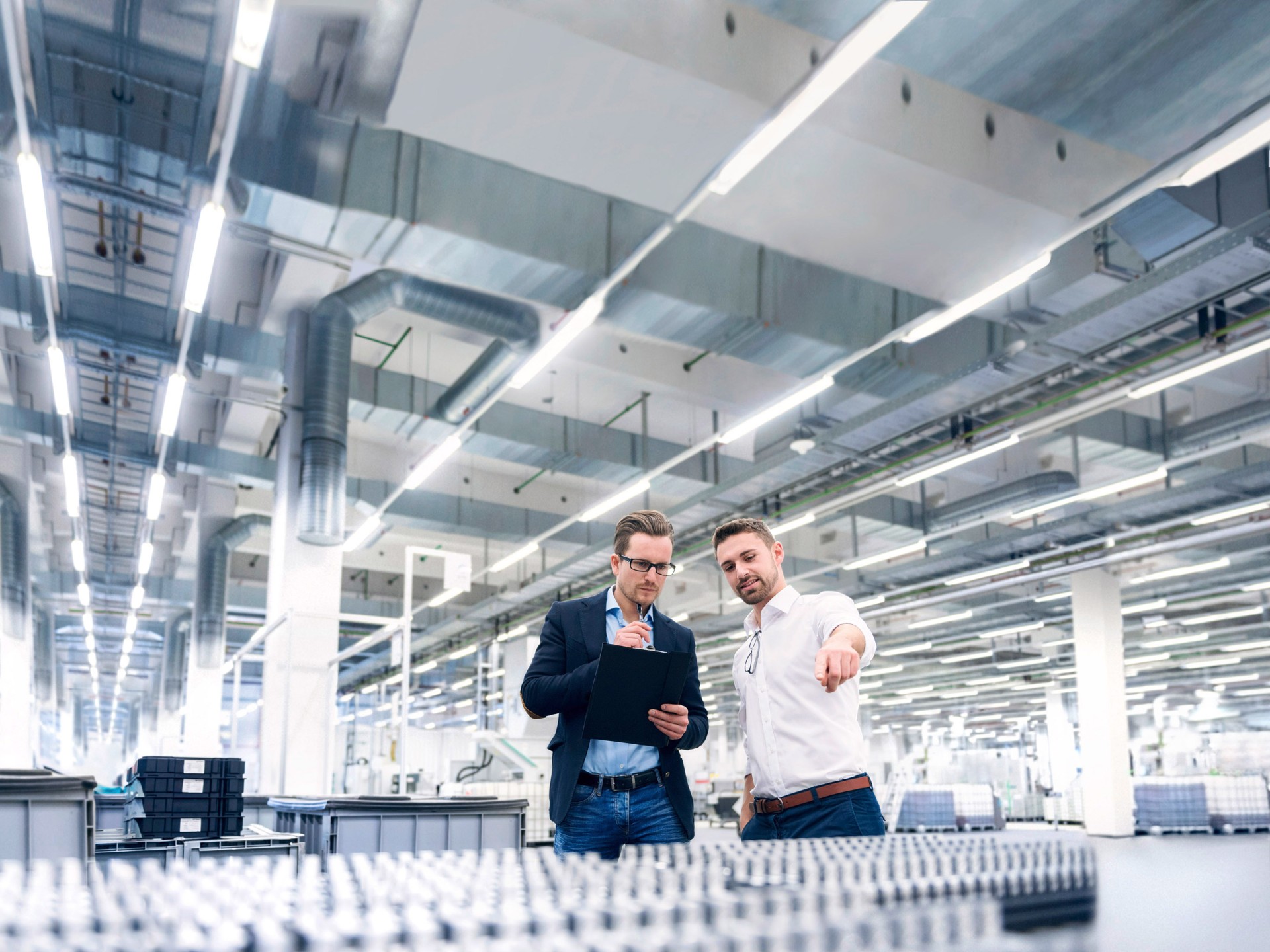 Two young men examine the products in a production hall