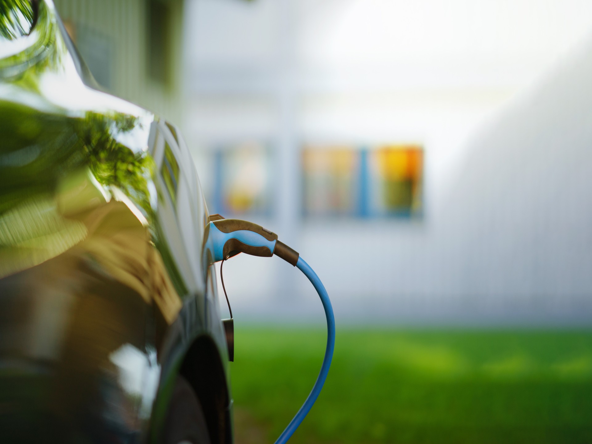 Ladekabel eingesteckt in einem Elektroauto vor einem wohngebäude