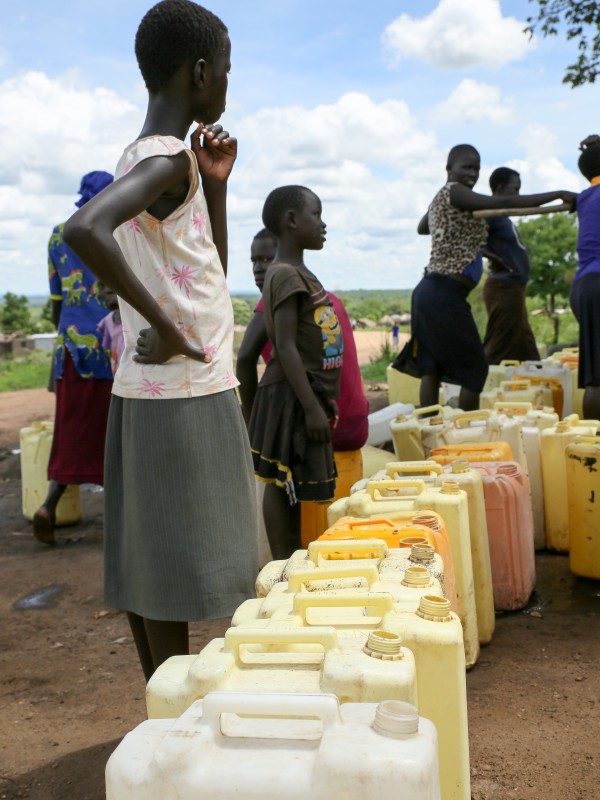 Woman with water canisters in line