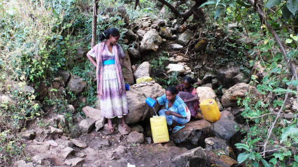 Frauen entnehmen Wasser an einer natürlichen Quelle in Äthiopien, Region Tigray
