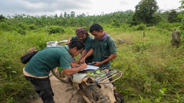 Three men of the wildlife protection unit taking data near Bukit Tigapuluh, Sumatra, Indonesia. 