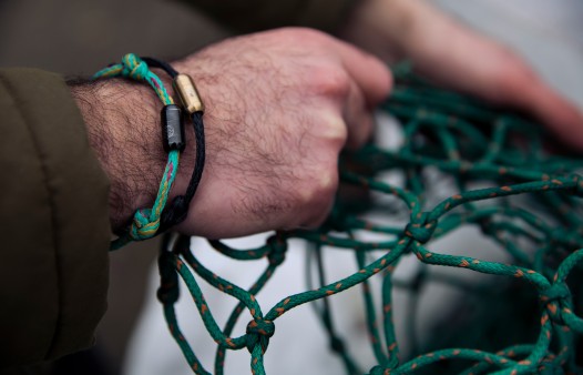 Male hand with bracelet from a used fishing net