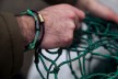 Male hand with bracelet from a used fishing net