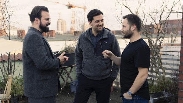 drei Männer unterhalten sich gut gelaunt auf einer Terrasse