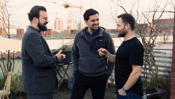 three men talking in a good mood outside on a patio