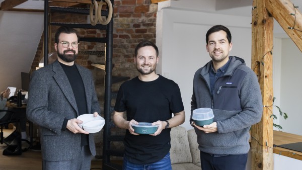 Die drei Crafting Future Gründer halten lächelnd ihr Produkt in den Händen