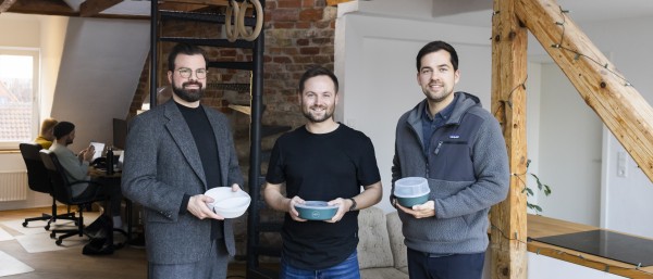 Die drei Crafting Future Gründer halten lächelnd ihr Produkt in den Händen