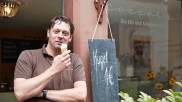 Jochen Jung probiert sein eigenes Eis vor seiner Eisdiele Coccola