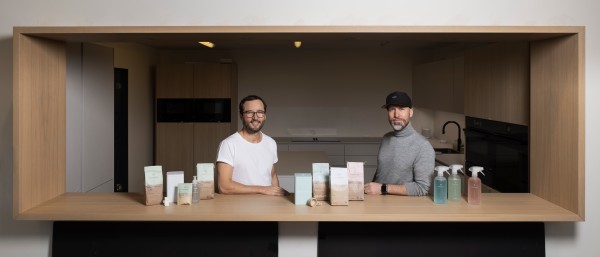 The two founders stand behind a counter on which the everdrop products are displayed.