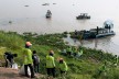 people on land, and a ship on sea collecting gargabe