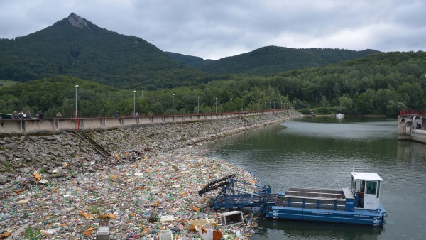 boat collecting garbage out of a river