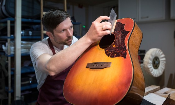 Gitarrenbauer Martin Meckbach arbeitet konzentriert an einem Gitarrenkorpus