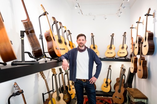 Martin Meckbach steht inmitten der Gitarren, die er zum Verkauf anbietet