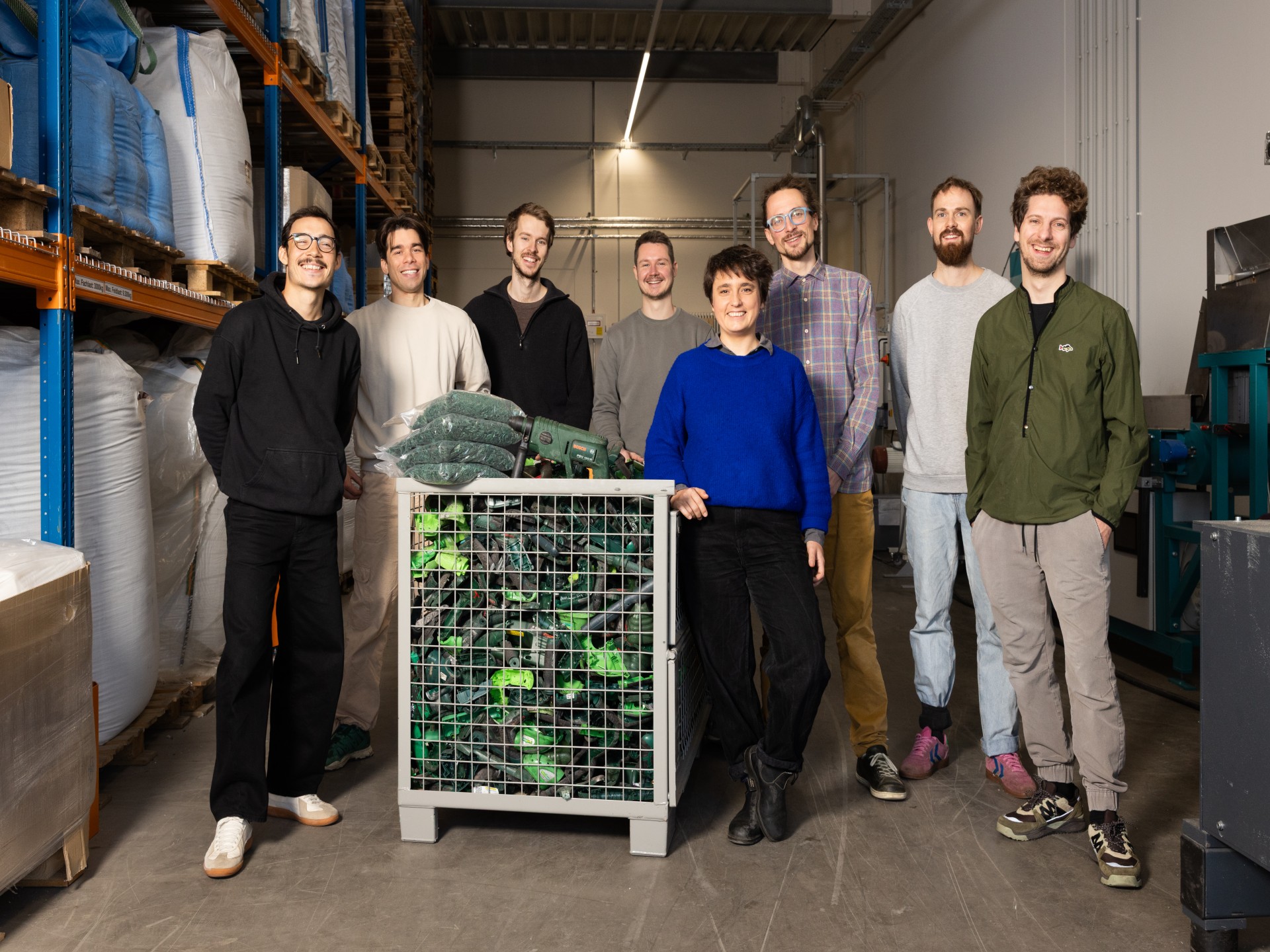 Das Team von HolyPoly in ihrem Lager neben einer Kiste mit aussortierten Bohrmaschinen. 