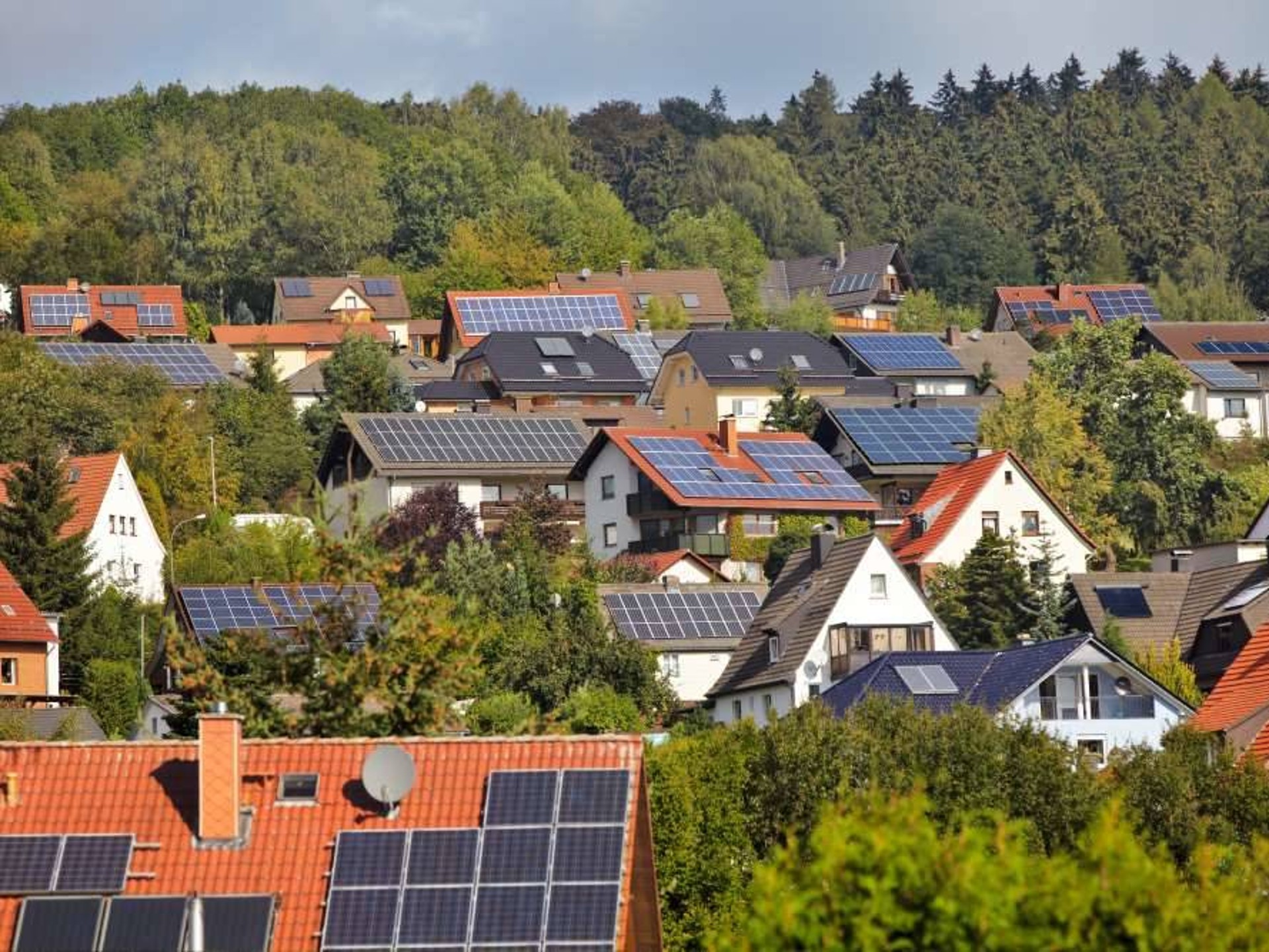 Panoramaaufnahme von mehreren Hausdächern mit Photovoltaikanlagen