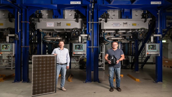 Wolfram Palitzsch and Dr. Ingo Röver (from left), founders of LuxChemtech, pose with a silicon block and a solar panel