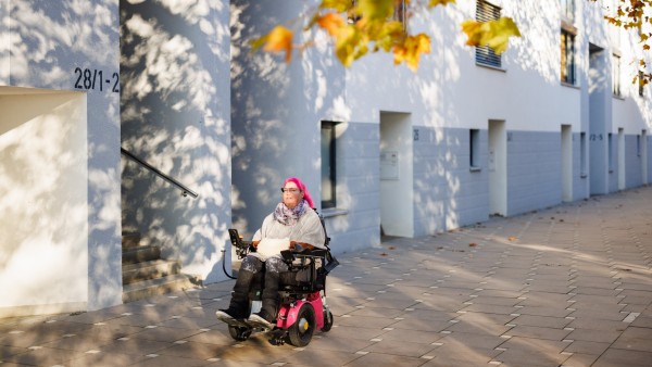 Saskia Melches fährt mit ihrem Rollstuhl durch eine Straße