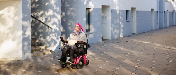 Saskia Melches fährt mit ihrem Rollstuhl durch eine Straße