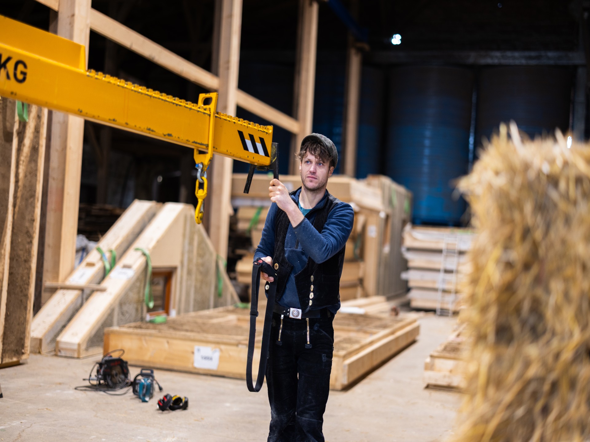 Ein Halm Mitarbeiter bedient einen Lastenkran in der Fertigungshalle