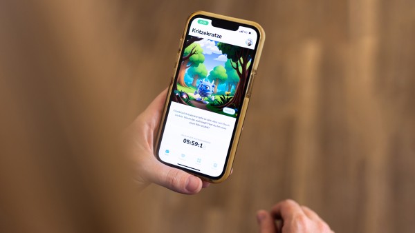 Eine Hand hält ein Smartphone auf der die Itxhy Monsters App zu sehen ist