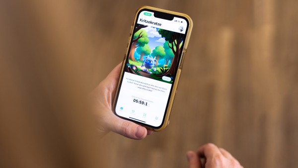 Eine Hand hält ein Smartphone auf der die Itxhy Monsters App zu sehen ist