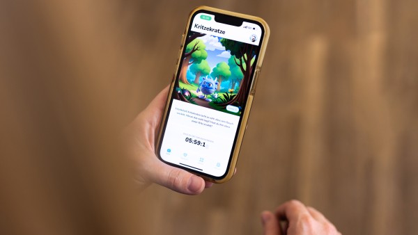 Eine Hand hält ein Smartphone auf der die Itxhy Monsters App zu sehen ist