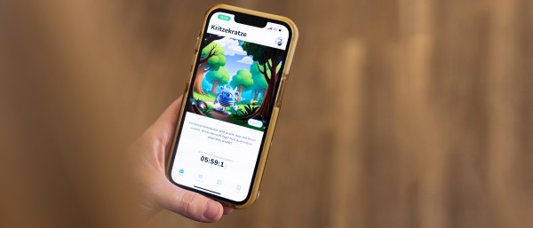 Eine Hand hält ein Smartphone auf der die Itxhy Monsters App zu sehen ist