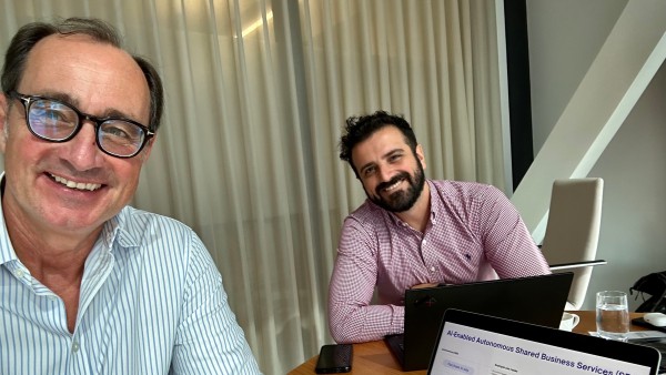 Foto von Hendrik Leitner, Head of Partnerships und Danail Delchev, Head of Partner Success Management sitzend am Tisch mit aufgeklappten Notebooks