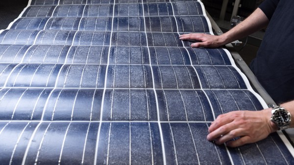  Zwei Hände auf einer Silitiumschicht eines recycelten Solarmoduls