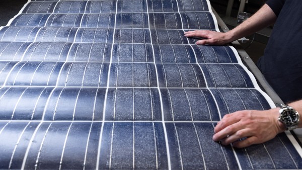  Zwei Hände auf einer Silitiumschicht eines recycelten Solarmoduls