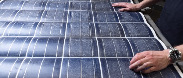  Zwei Hände auf einer Silitiumschicht eines recycelten Solarmoduls