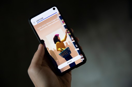 Eine Hand hält ein Smartphone und absolviert eine Lektion der Sympatient App