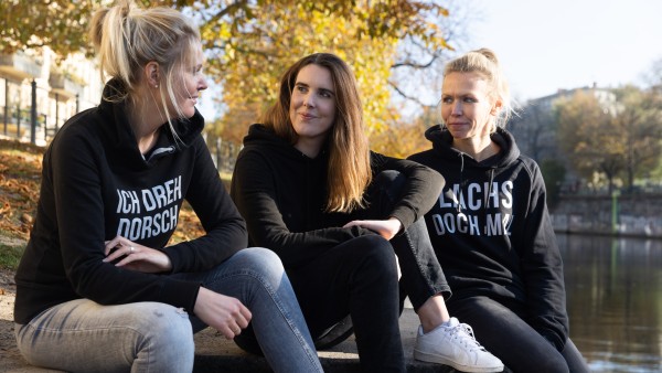 Three women sitting next to each other talking