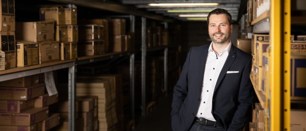 weLOG founder Manuel Rupp stands leaning against a storage shelf 