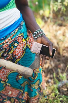 A hand of a woman from Guinea holding a mobile phone