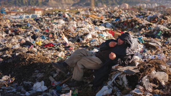Liegender Mann auf Müllkippe