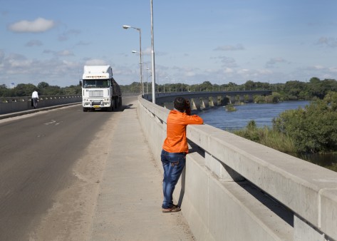 Ein Mann blickt über das Brückengeländer auf den Fluss