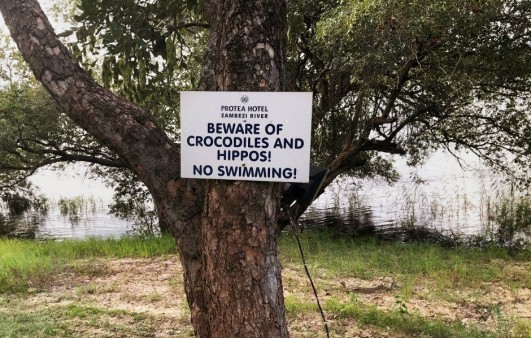 Warning sign: Beware of crocodiles and hippos! No swimming!