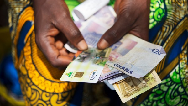 e-zwich-Karte und Banknoten in den Händen einer Frau aus Ghana